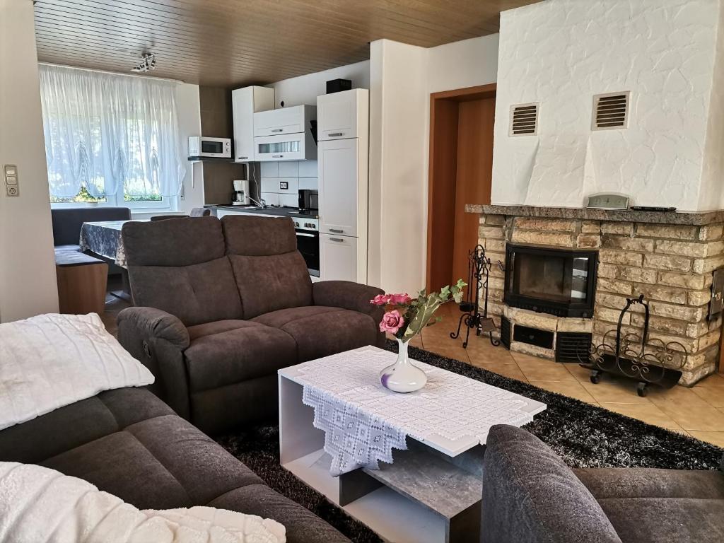 a living room with two couches and a fireplace at Ferienhaus Happel in Bad Endbach