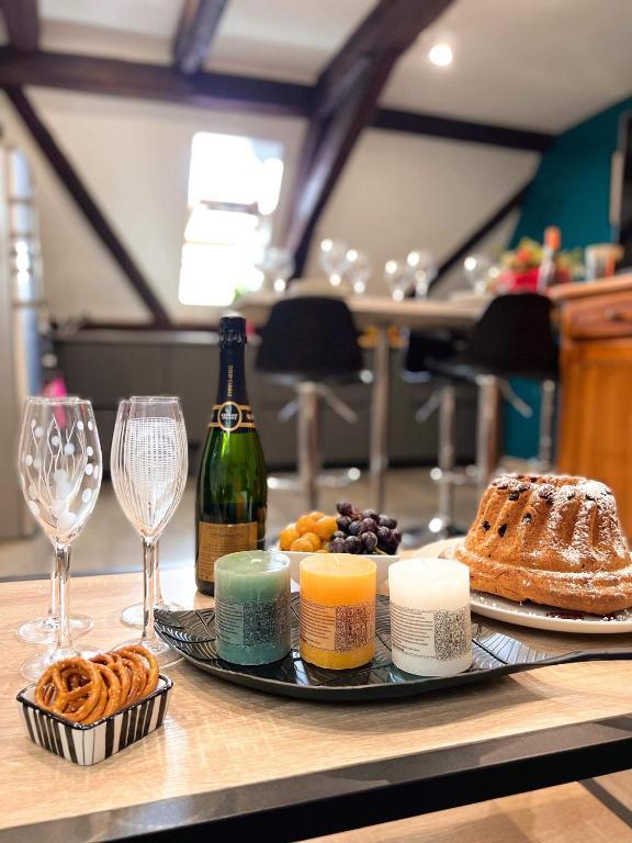 - une table avec une assiette de nourriture et une bouteille de vin dans l'établissement Gîte du Figuier 4 à 6 personnes Sélestat Centre-Alsace, à Sélestat