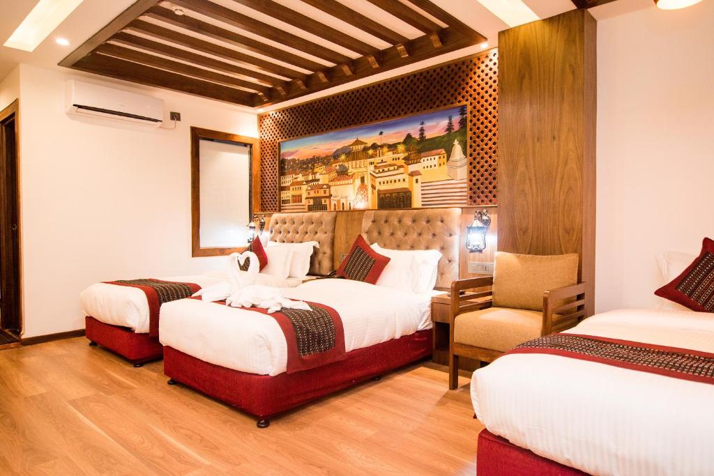 a hotel room with two beds and a chair at Everest Boutique Hotel in Kathmandu