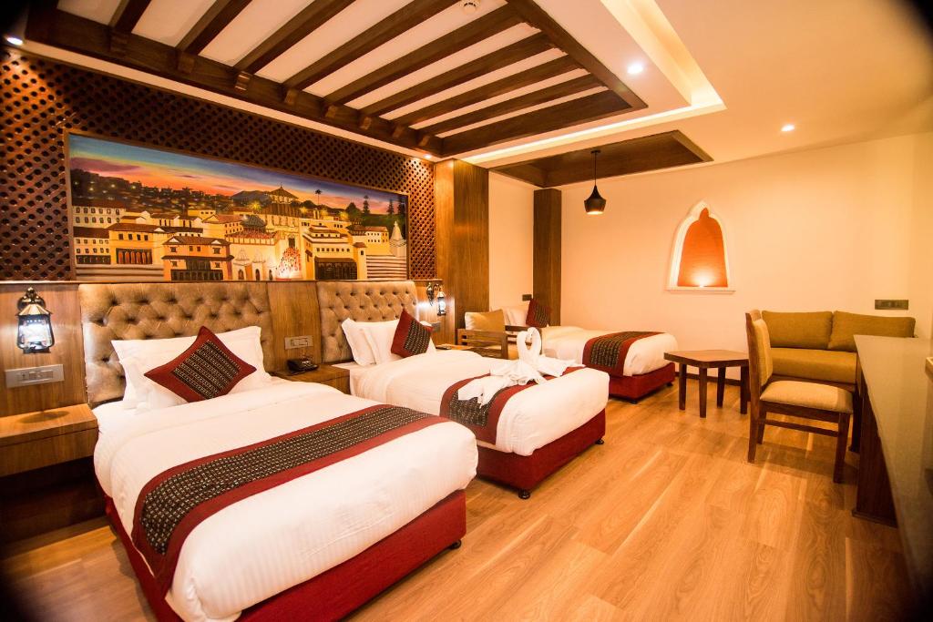 a hotel room with two beds and a table and chairs at Everest Boutique Hotel in Kathmandu