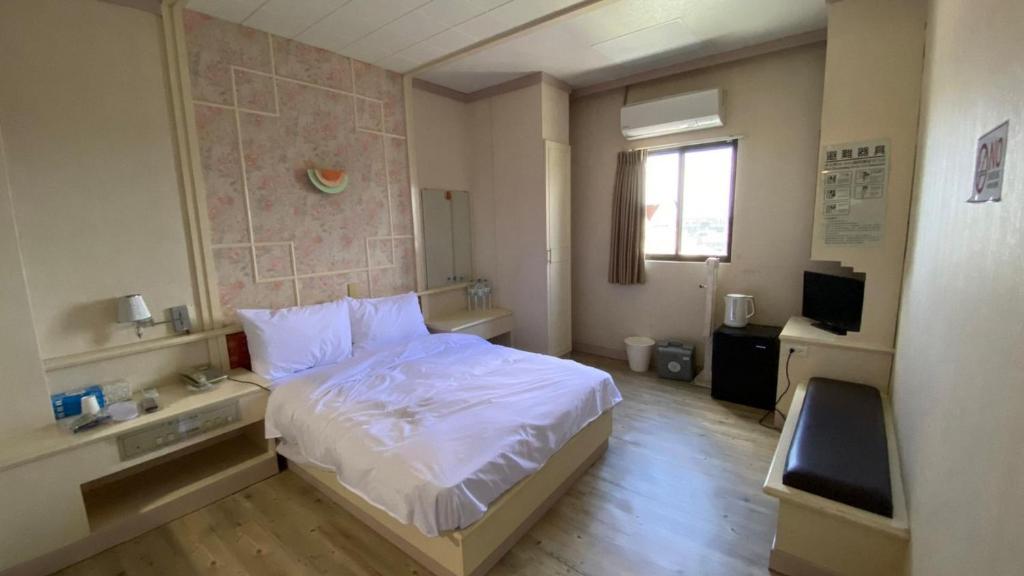 - une chambre avec un lit blanc et une fenêtre dans l'établissement 日日 Meworld, à Beigang