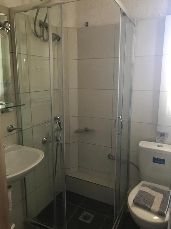 łazienka z prysznicem, toaletą i umywalką w obiekcie Chaliotis Apartments w mieście Chalkida