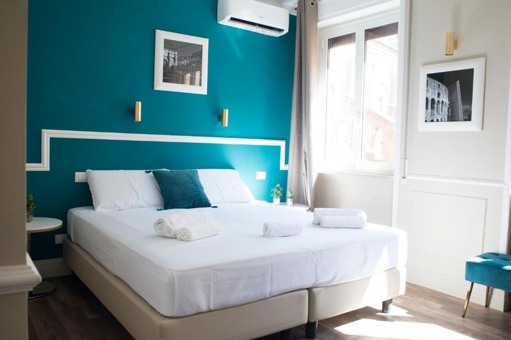 a bedroom with a white bed with a blue wall at Le Petit Bijou in Rome