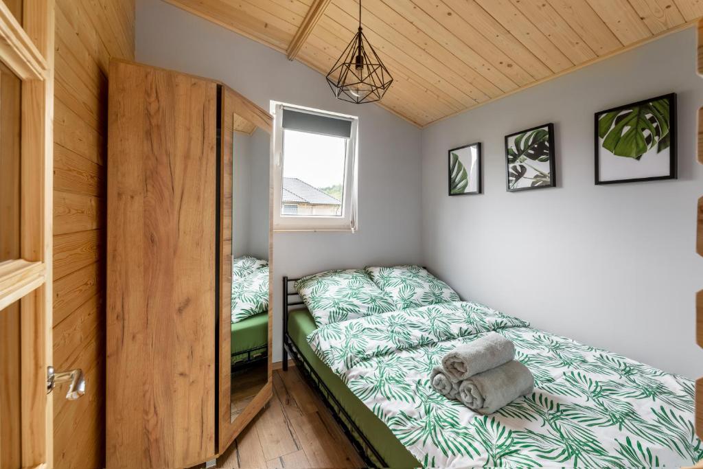 um pequeno quarto com uma cama e uma janela em Tobiaszówka em Kudowa-Zdrój