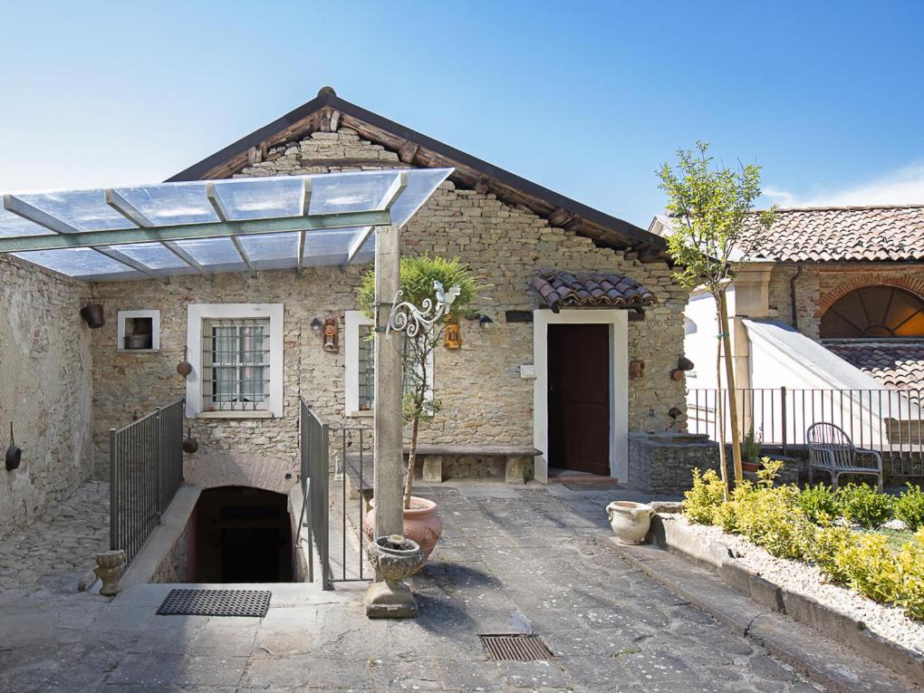 a stone house with a wooden door and a fence at Casa Cecilia in Santo Stefano Belbo