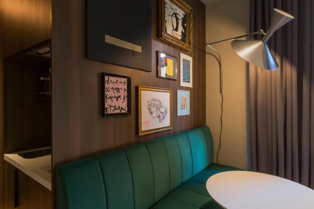 a living room with a green couch and a table at Bona Fide Main Square Designer Apartments in Zagreb