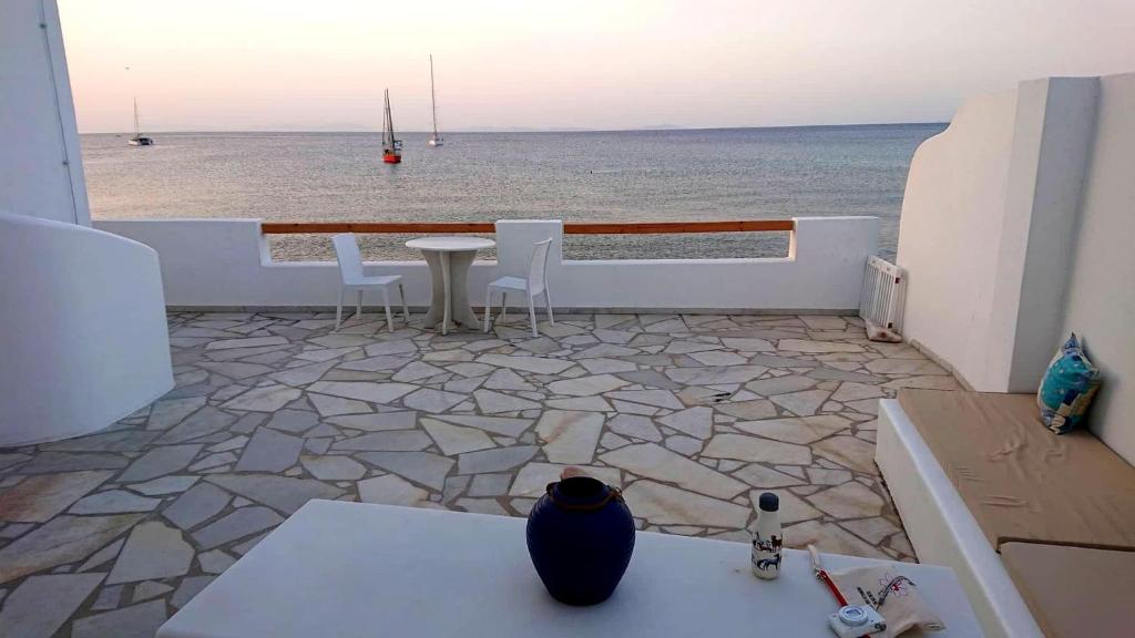 a patio with a table and chairs and the ocean at Ma mer in Naxos Chora