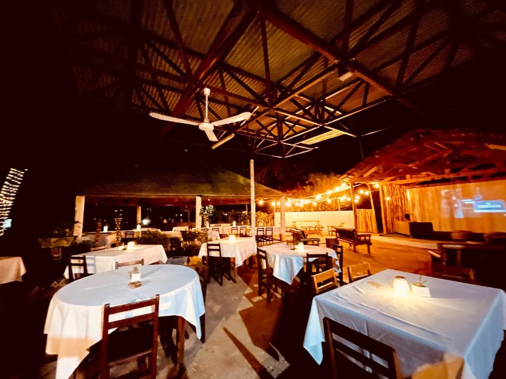 トゥリアラにあるCHEZ ALAINの天井のレストラン(白いテーブルと椅子付)