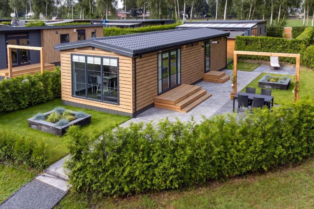 une petite cabine dans une cour avec une terrasse dans l'établissement Recreatiepark Maas en Bos, à Wellerlooi