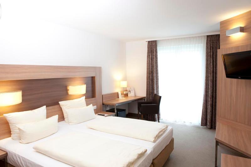 a hotel room with a large bed and a desk at sleep in - Bielefeld Boardinghouse in Bielefeld