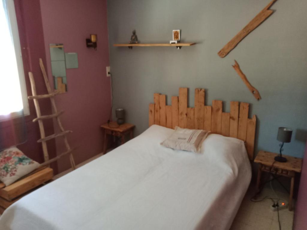 a bedroom with a bed with a wooden headboard at Chambre chez l'habitant in Pierrelatte