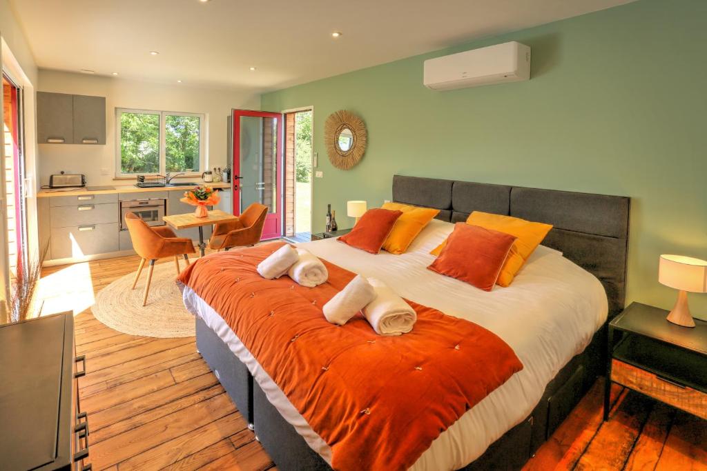 a bedroom with a large bed with orange and white pillows at l'Escapade in Saint-Fargeau