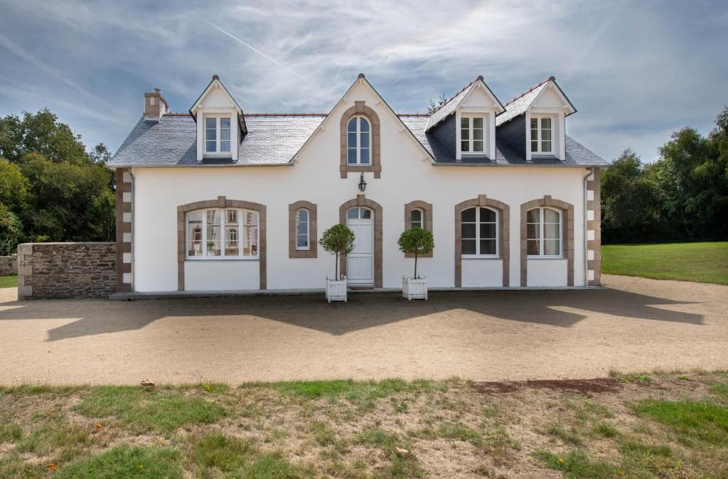 une maison avec deux plantes en pot devant elle dans l'établissement L'Annexe du Manoir - A proximité de Carantec, à Taulé