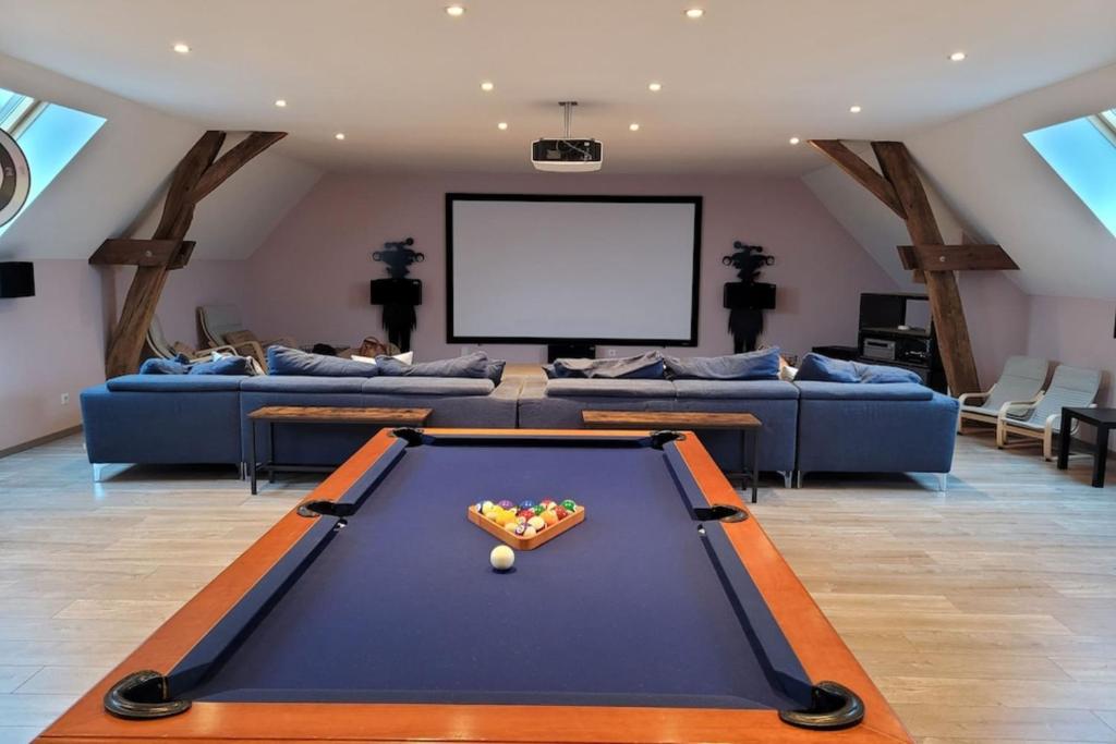 a living room with a pool table and a screen at Maison avec piscine pour 10 adultes et 8 enfants ou ados 