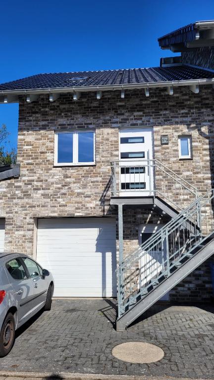 a car parked in front of a brick house at Schöne Maisonette Düren in Düren - Eifel