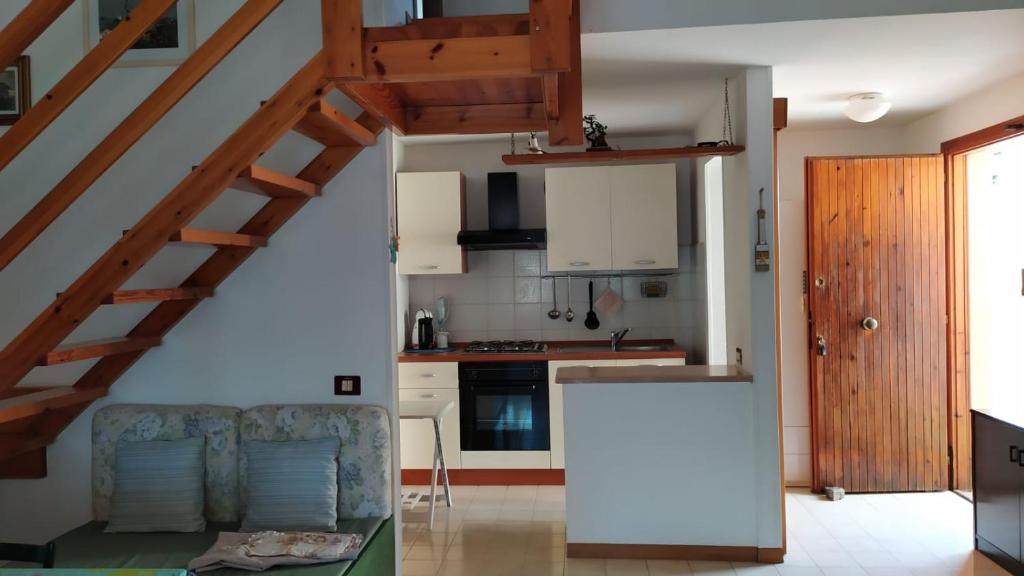 een woonkamer met een bank en een keuken bij CASA VACANZE ARBORIAMAR SORSO SARDEGNa in Marina di Sorso