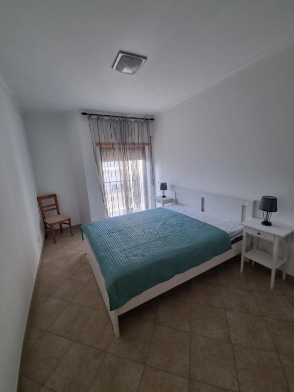 a bedroom with a bed and a table and a window at Ocean pearl in Lagos