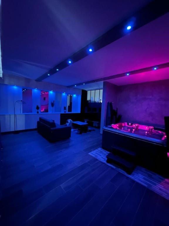 sala de estar con mesa de billar e iluminación púrpura en LE 46 : Superbe appartement jacuzzi, en Besançon