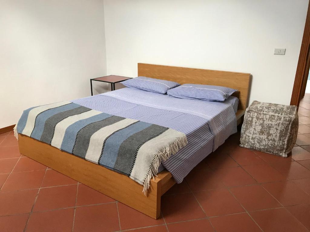 a bedroom with a bed with a striped blanket and a chair at Casa di Luca in Viareggio