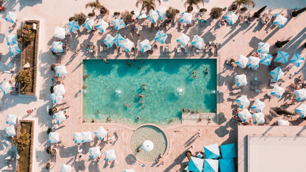 una vista aérea de una piscina con personas y sombrillas en Palmon Bay Hotel & Spa, en Herceg-Novi