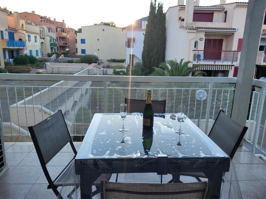- une bouteille de vin assise sur une table sur un balcon dans l'établissement Superbe T2 en centre ville au calme à deux pas du marché, à Cavalaire-sur-Mer