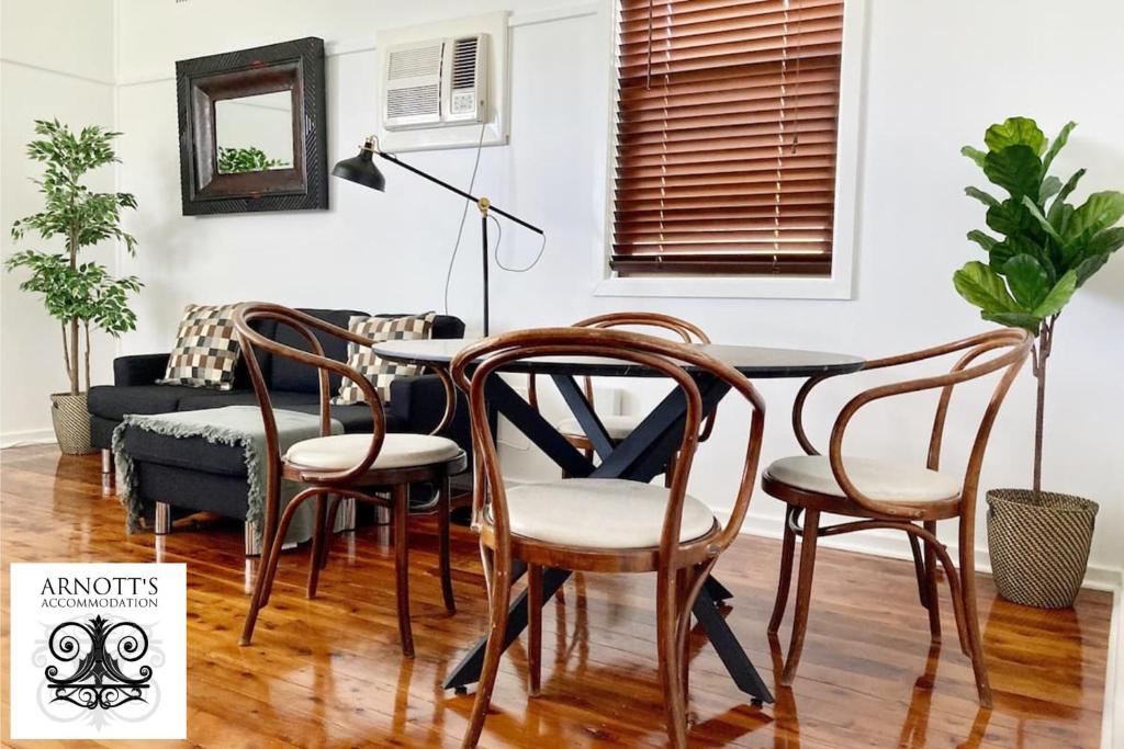a dining room with a table and chairs at Fieldsend Cottage in East Maitland