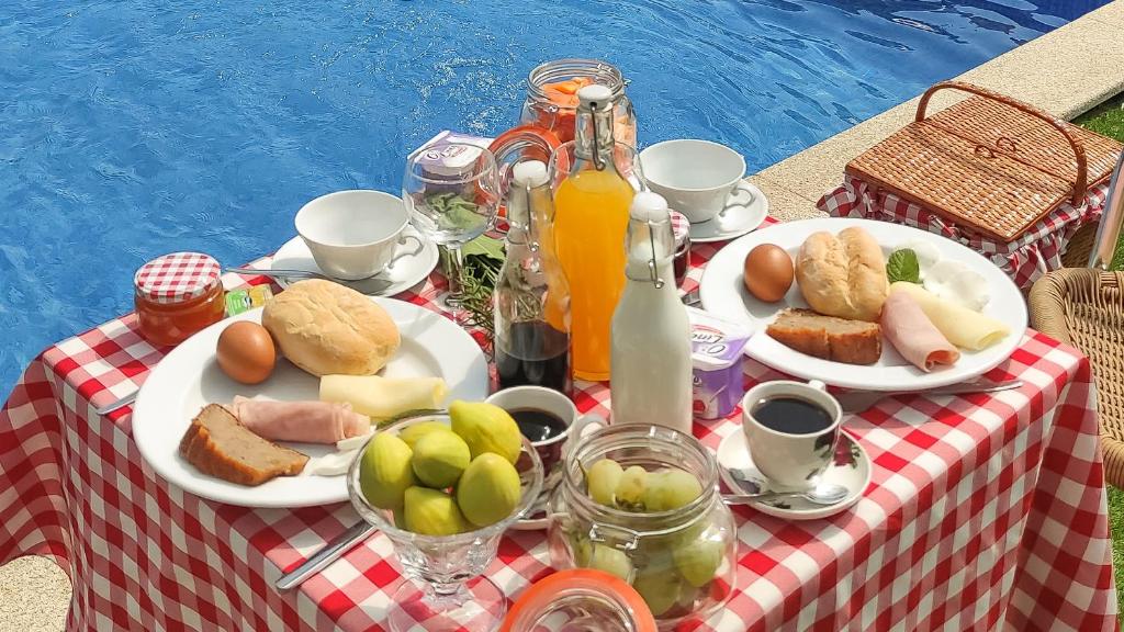 a picnic table with plates of food and drinks at Quinta dos Padrinhos - Suites in the Heart of the Douro in Lamego