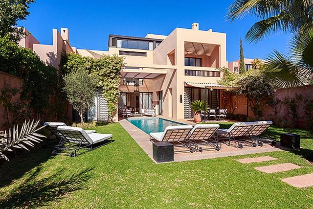 a house with chairs and a swimming pool in the yard at Al Maaden Ryad 69 a Marrakesh in Marrakesh