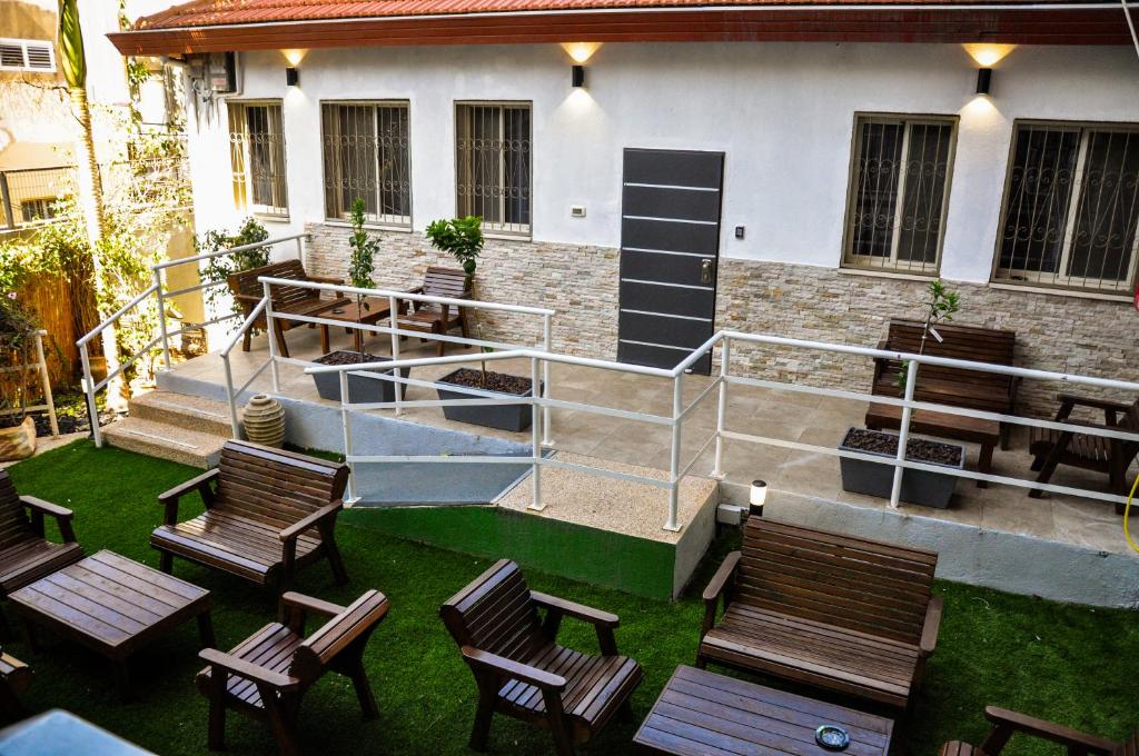 um grupo de cadeiras sentadas em frente a um edifício em Zimmer Garden em Haifa