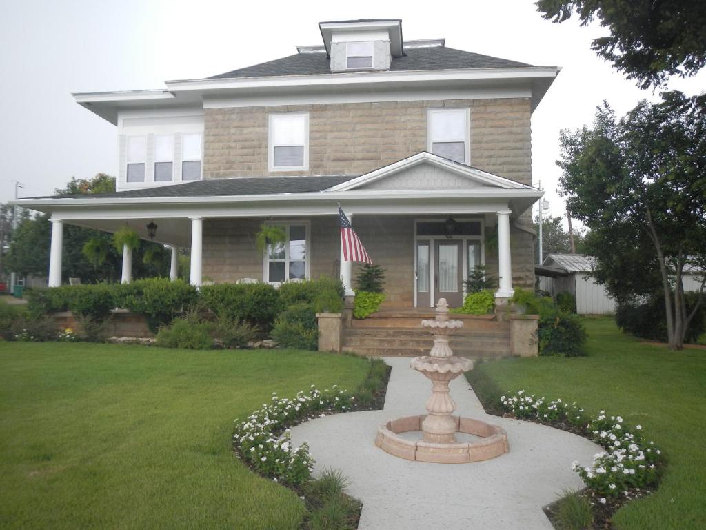 a house with a flag and a fountain in the yard at Sandstone Street Bed and Breakfast in Llano