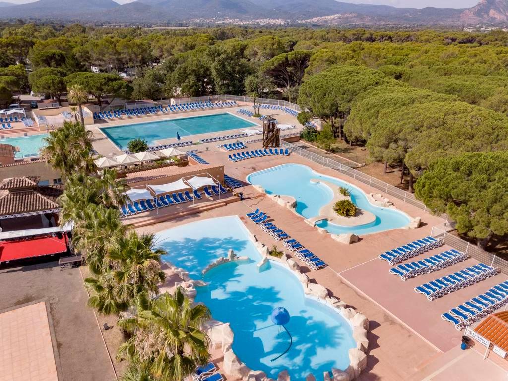 an overhead view of a resort pool with blue water at Camping Oasis Village in Puget-sur-Argens