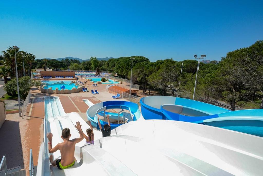 a large swimming pool with people at a water park at Camping Oasis Village in Puget-sur-Argens