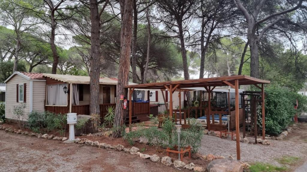 a small house with a pergola and a playground at Camping Oasis Village in Puget-sur-Argens