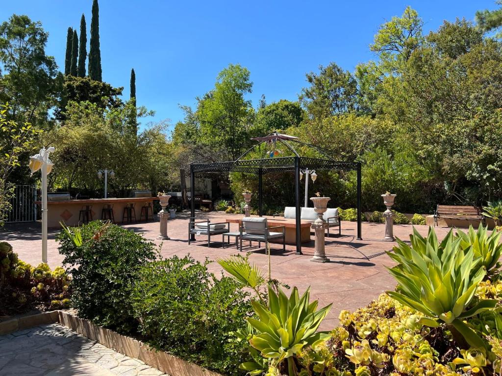 un patio con mesas y sillas en un jardín en Vacation Paradise - 6 BR Mansion on Top of Encino Hills en Topanga