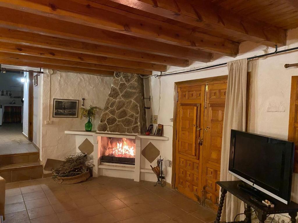 sala de estar con chimenea y TV en El balcón de Reznos, Soria, en Soria