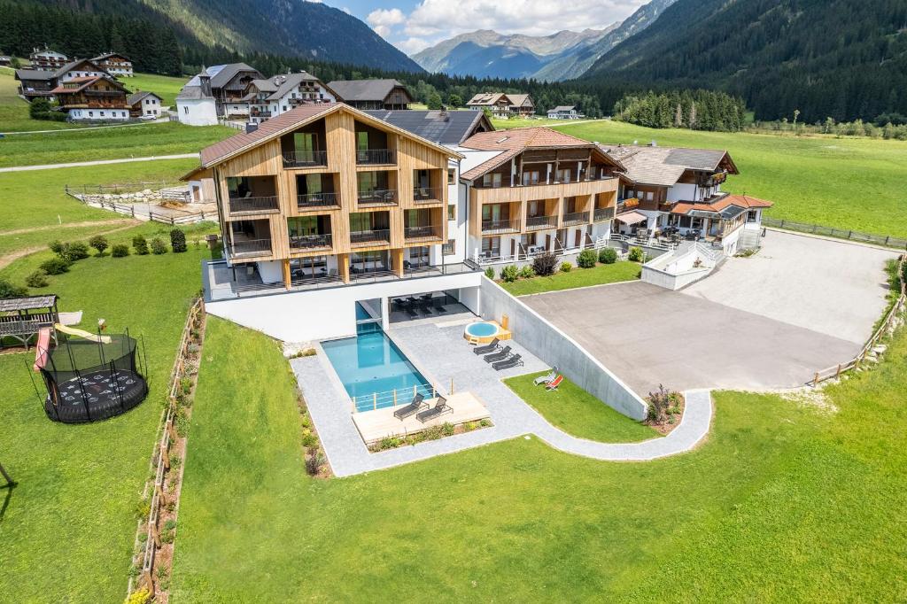 an aerial view of a large house with a pool at Hotel Tyrol in Valle Di Casies
