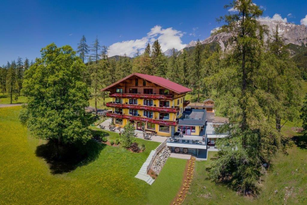 an aerial view of a large house in the mountains at Hotel Rösslhof in Ramsau am Dachstein