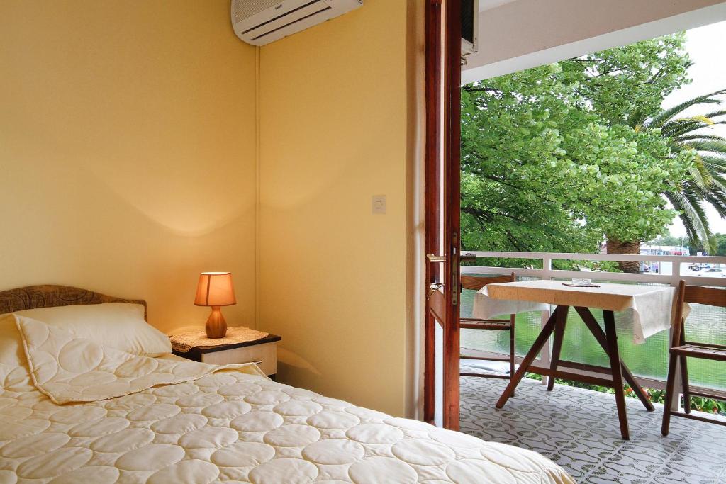 a bedroom with a bed and a balcony with a desk at Apartments Boris in Budva