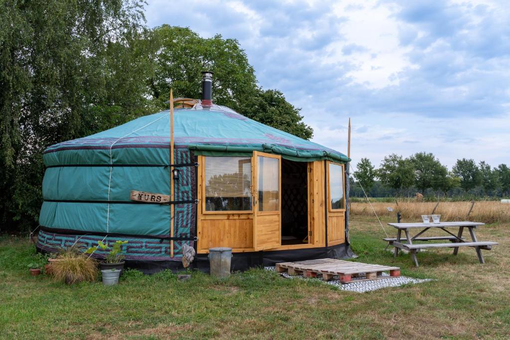 a yurt with a picnic table in a field at YURs in Baexem