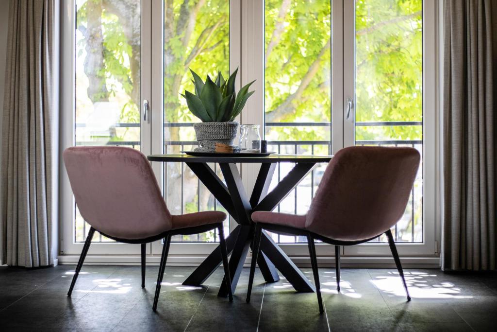 uma mesa e duas cadeiras em frente a uma janela em Appartement de Hoge Stoep em Hollum