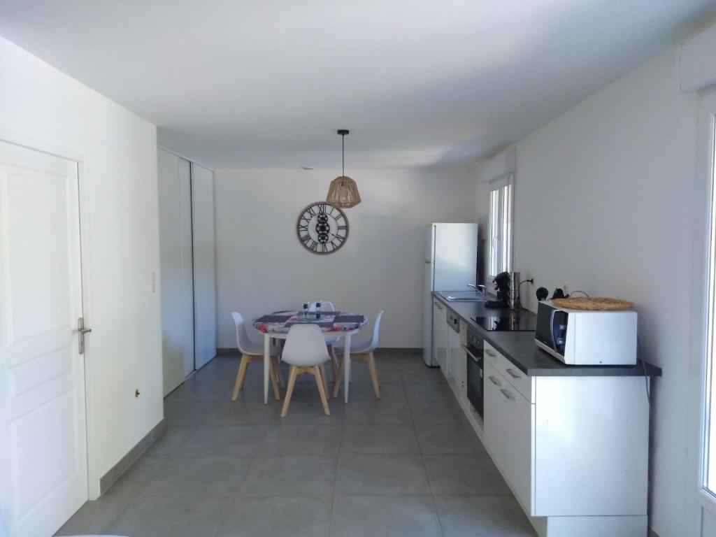 a kitchen and dining room with a table and a microwave at Studio Les Ecureuils in Pont-dʼAin