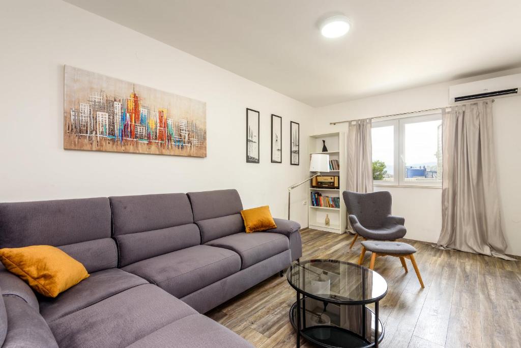 ein Wohnzimmer mit einem Sofa und einem Stuhl in der Unterkunft Apartment Tina in Ploče