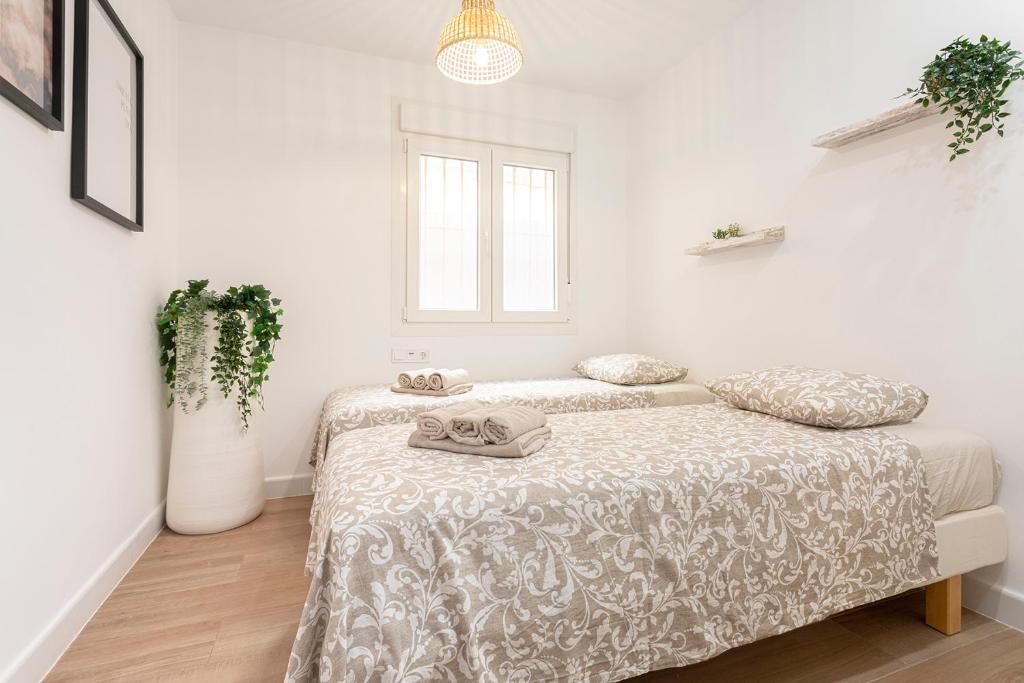 A bed or beds in a room at Malgi Apartment - Malaga City Centre