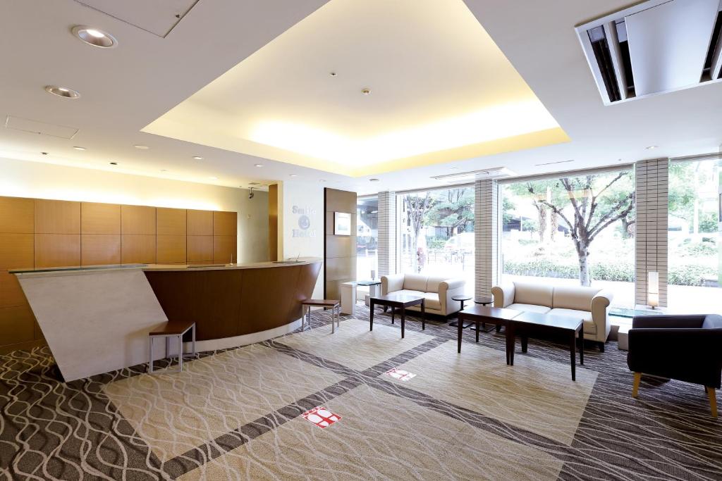 een wachtkamer in een ziekenhuis met stoelen en tafels bij Smile Hotel Osaka Yotsubashi in Osaka