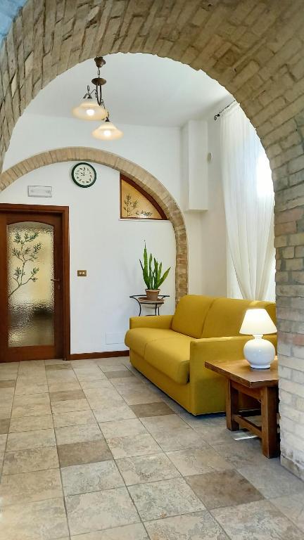 a living room with a yellow couch and a table at La Casa Di Famiglia in Assisi