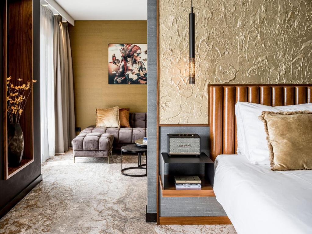 - une chambre avec un lit et un salon dans l'établissement Alexander Hotel, à Noordwijk aan Zee