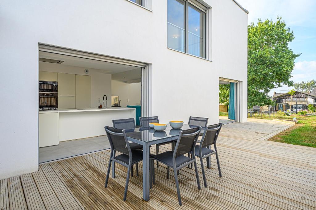 een eetkamer met een tafel en stoelen op een terras bij RETOUR DE PLAGE - Maison familiale à 400 m de la plage! in Arradon