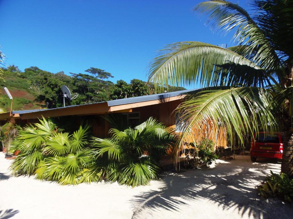 ein Gebäude mit Palmen davor in der Unterkunft Fare Ara Location Huahine in Fare