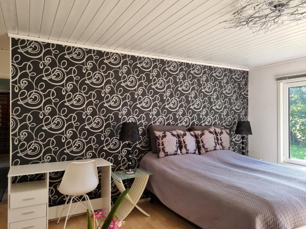 a bedroom with a bed and a black and white wall at Apartment Steinsgård-Maura in Maura