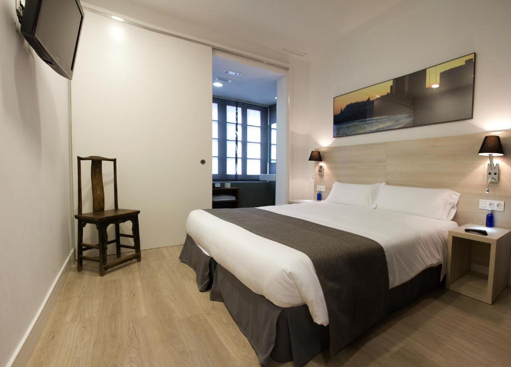 um quarto de hotel com uma cama e uma televisão de ecrã plano em The 8 Boutique B&B em Barcelona